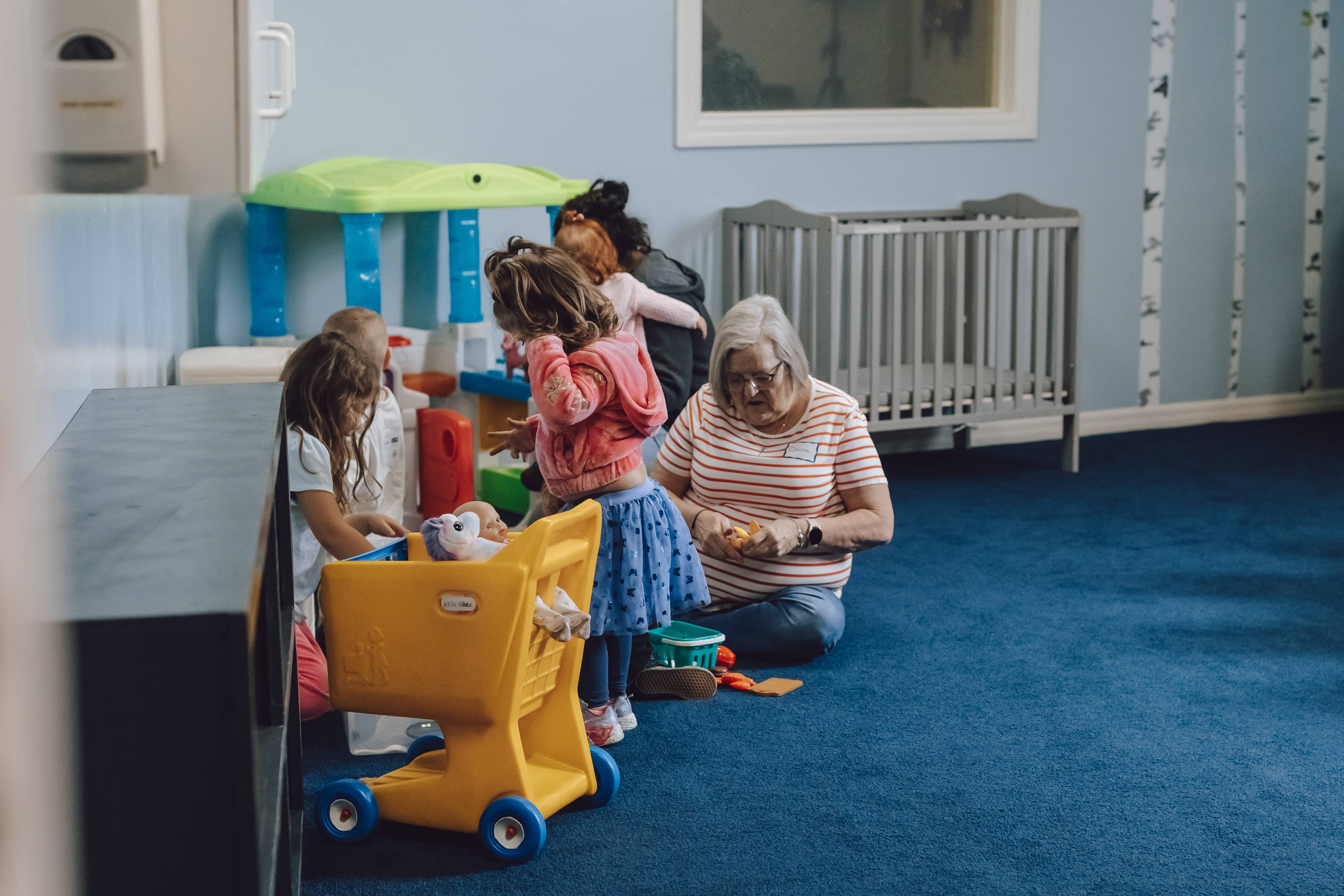 Kids playing in the Hope Kids babies room with volunteers